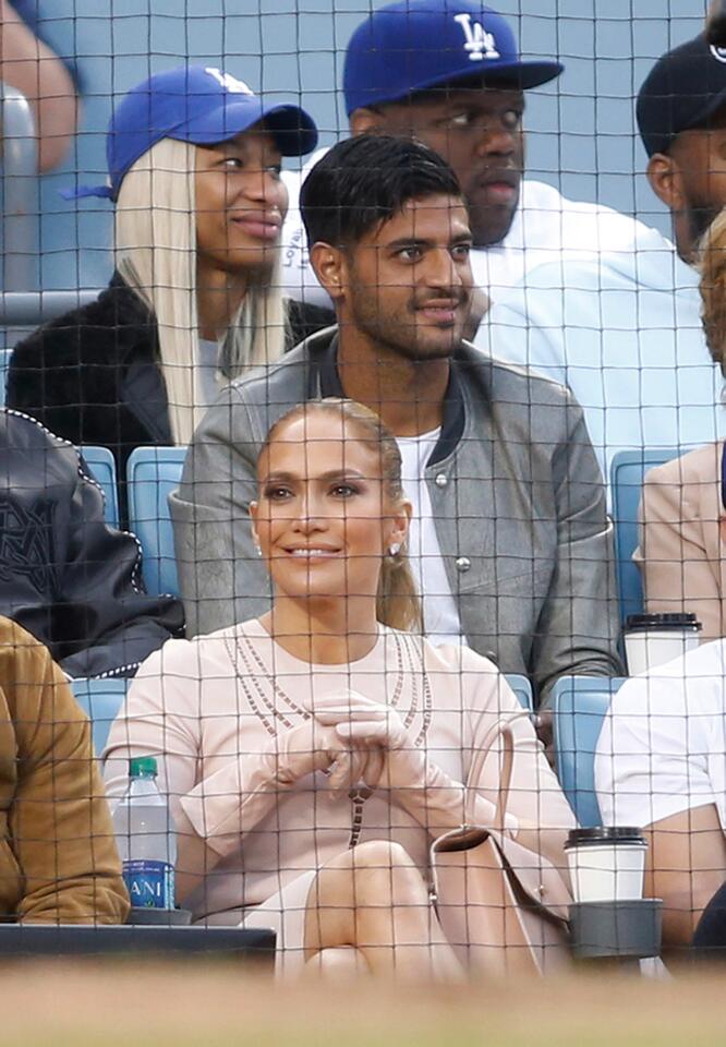 Actress Jennifer Lopez, bottom, and soccer player Carlos Vela, center, attend the baseball game between the Los Angeles Dodgers and San Francisco Giants at Dodger Stadium on Sunday, April 1, 2018, in Los Angeles. The Dodgers won 9-0. (AP Photo/Danny Moloshok)