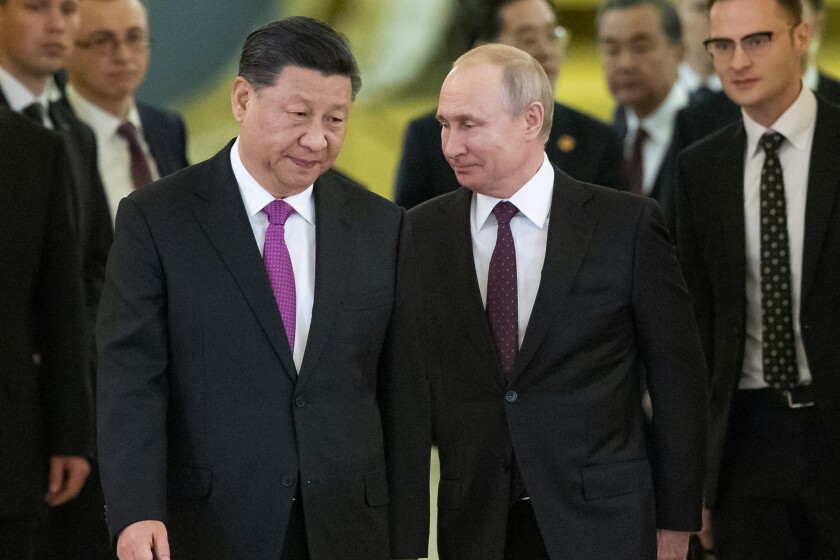 FILE - Chinese President Xi Jinping and Russian President Vladimir Putin enter a hall for talks in the Kremlin in Moscow, Russia, June 5, 2019. The U.S., Britain and a handful of others aren’t sending dignitaries to the Beijing Games as part of a diplomatic boycott, but the Chinese capital is still attracting an array of world leaders for Friday’s opening ceremony. Russia’s athletes will be competing under a neutral flag, but the presence of Putin, an enthusiastic skier and hockey player, will reinforce that they are the Russian national team in all but name and soothe wounded national pride. (AP Photo/Alexander Zemlianichenko, Pool, File)