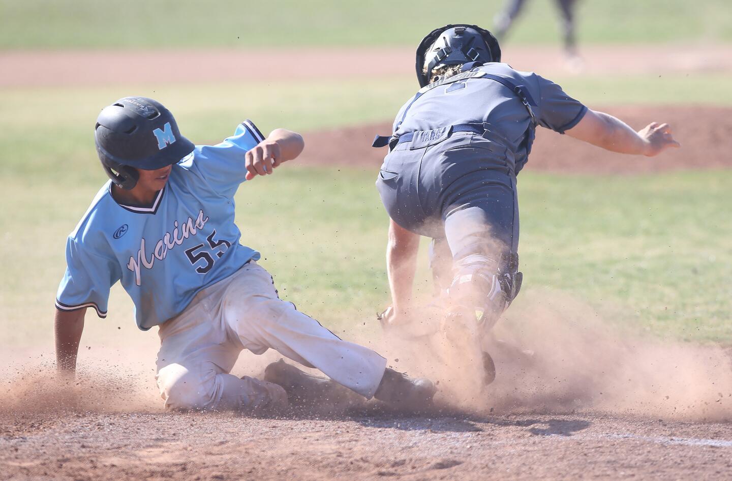 Marina's Zane Parmenter is out at home as Newport Harbor catcher Clay Liolios gets the ball in time during a Wave League game on Tuesday.