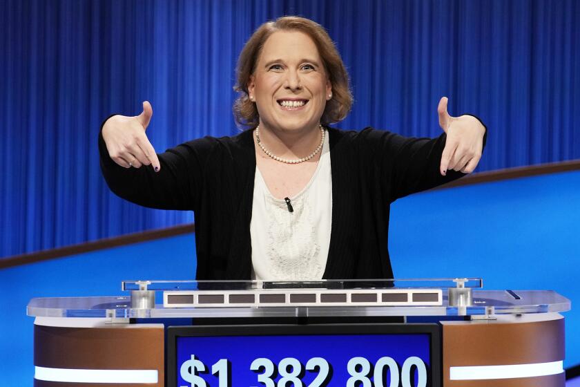 Amy Schneider standing behind a podium, smiling and pointing to a blue screen that says "$1,382,800"