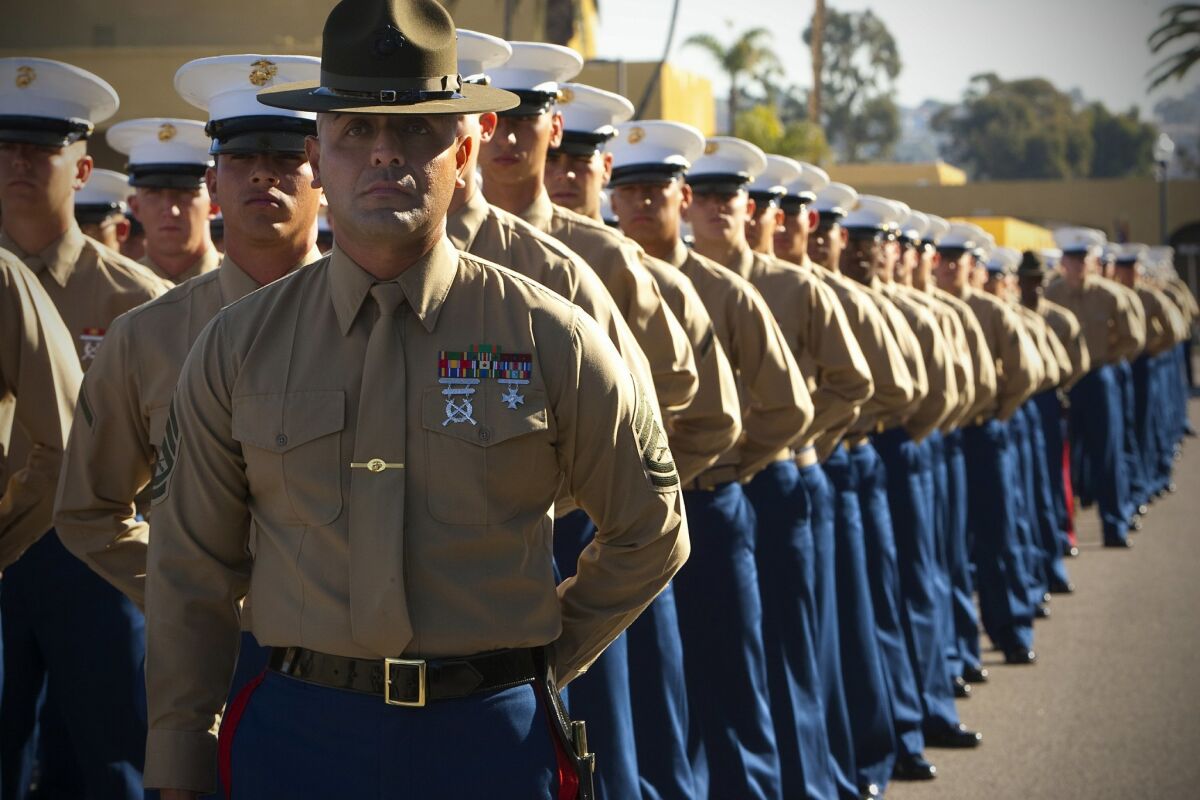 Marine recruits about to graduate from boot camp remain under their drill instructor's watchful eye at Marine Corps Recruit Depot San Diego. On Thursday, the Marines suspended all public boot camp graduations due to the spreading coronavirus.