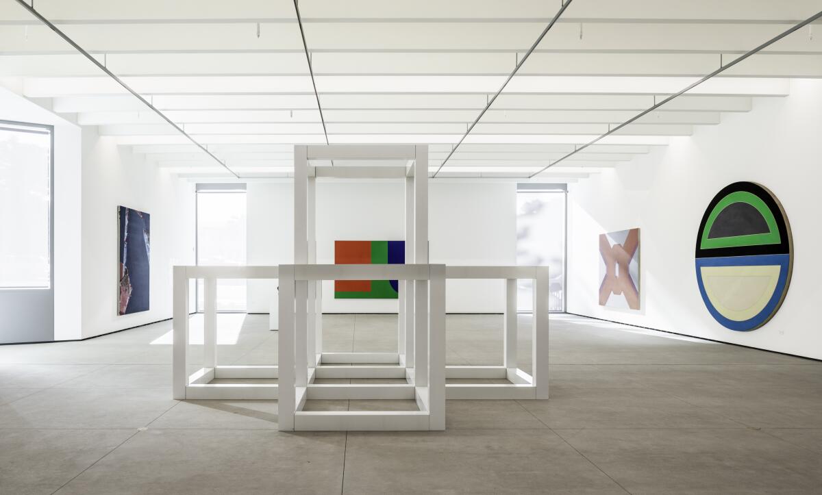 A sunlit gallery with white walls shows geometric/minimalist works.