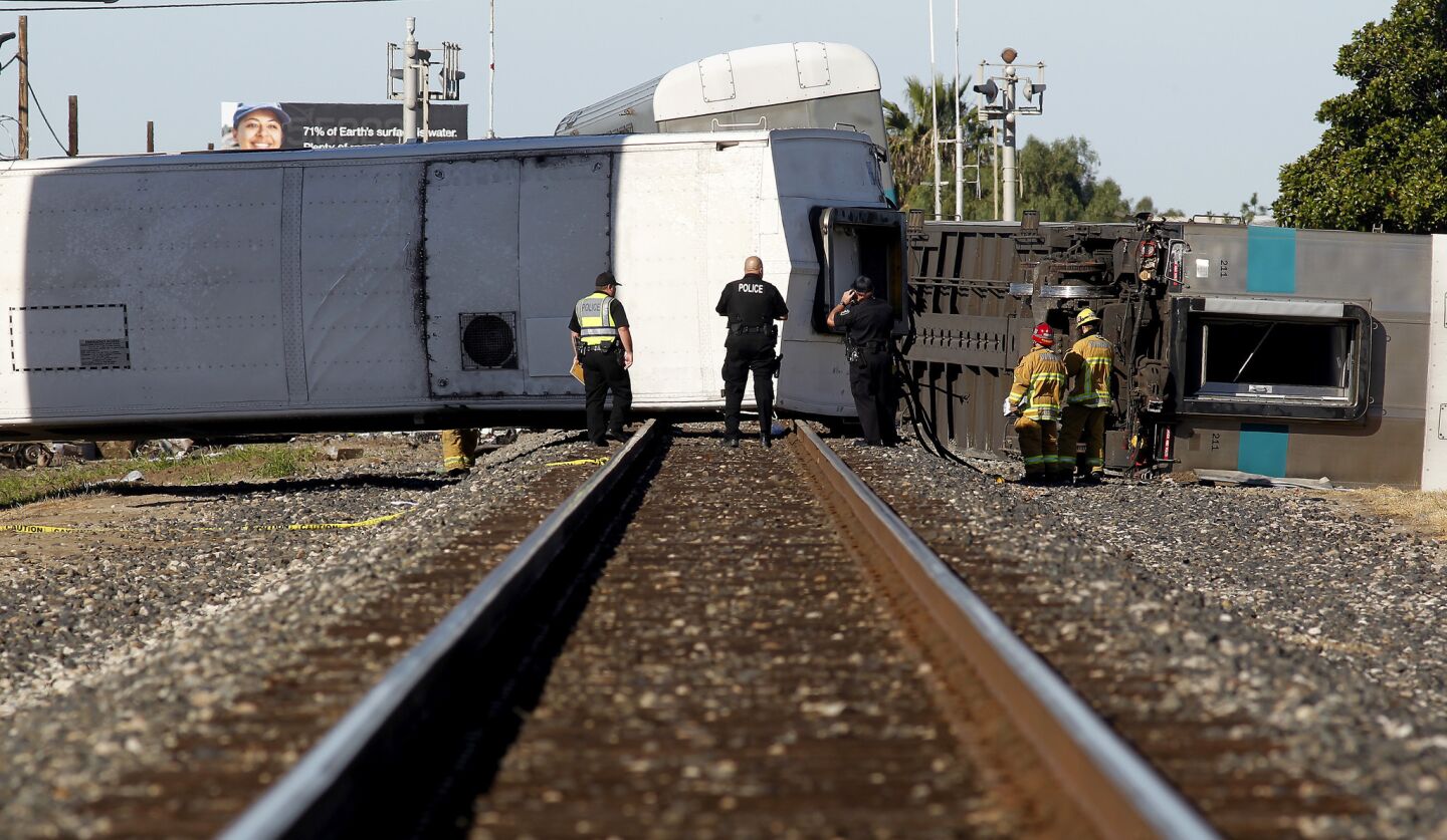 Officials examine a Metrolink train that derailed in Oxnard early Tuesday morning.