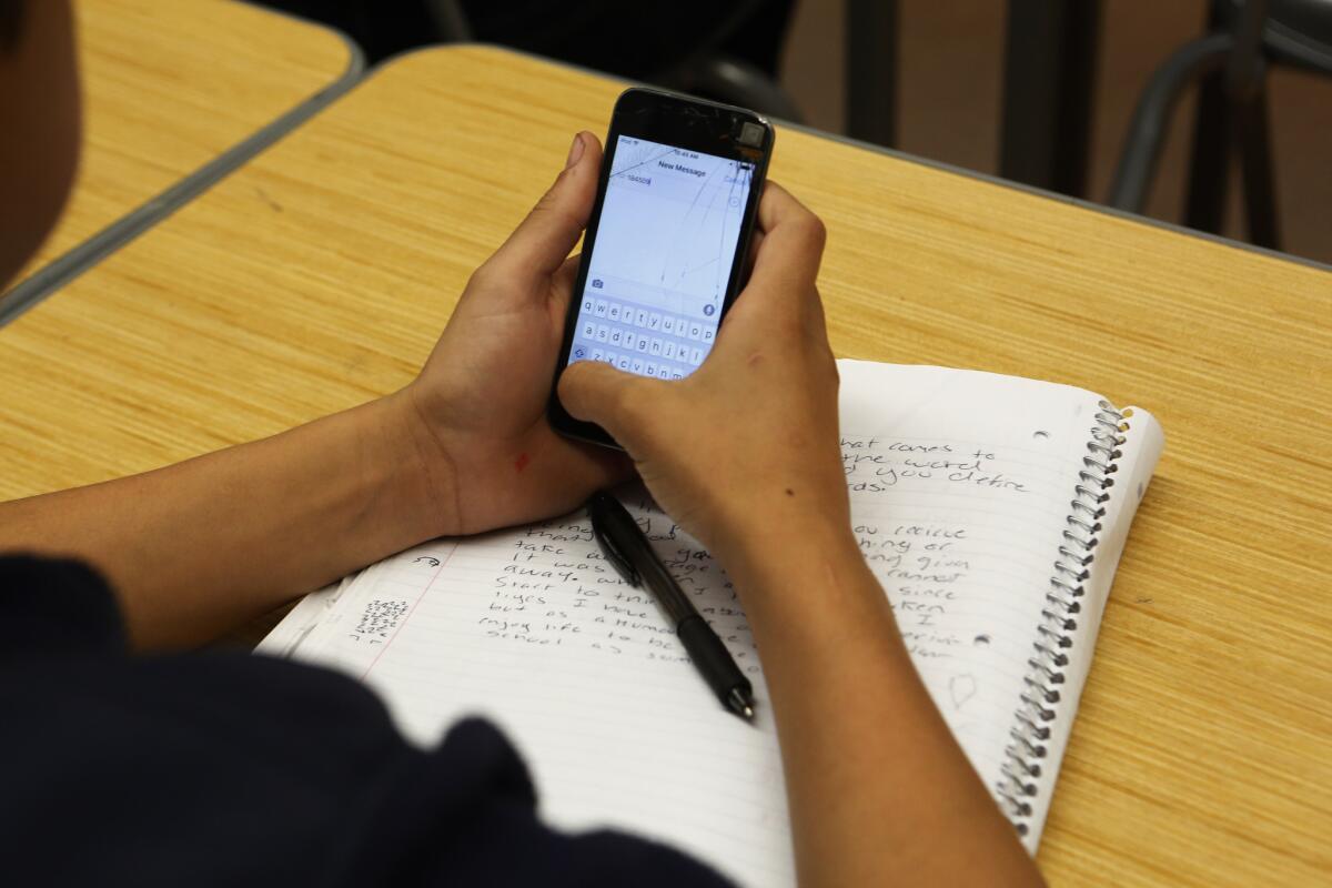 This student is using a cellphone to answer questions in class, but other uses might soon be grounds for expulsion.