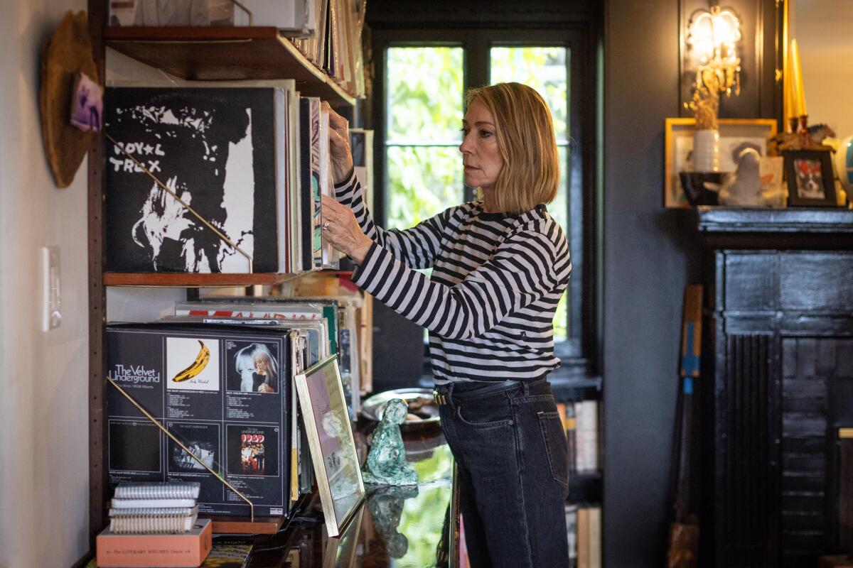 Woman at home looking through shelves of her record collection