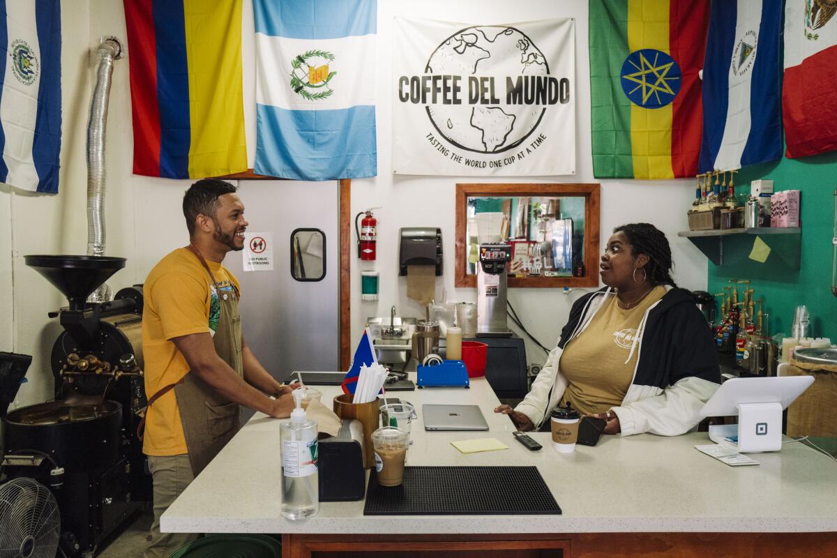 Jon Kinnard (left), the owner of Coffee Del Mundo, speaks wtih Ariana Brewer, the shop manager