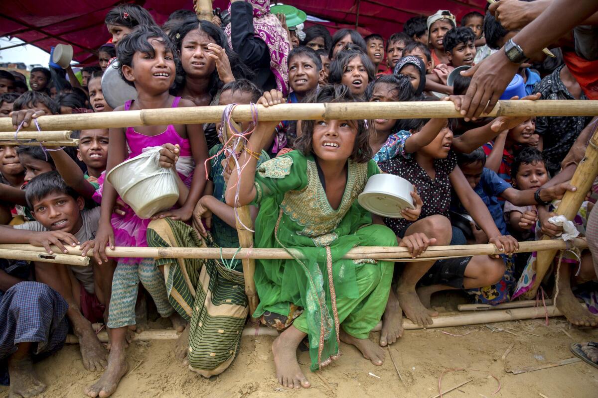 Rohingya Muslim children, who crossed from Myanmar into Bangladesh, wait for their turn to receive food handouts distributed to children and women by a Turkish aid agency at Thaingkhali refugee camp in Bangladesh.