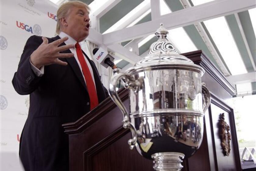 Donald Trump gestures during a news conference at Trump National in Bedminster, N.J., Thursday, May 3, 2012. The 65-year-old real estate mogul, TV personality and casino owner is going to be the host for the U.S. Women's Open in 2017. At right foreground is the U.S. Women's Open trophy. (AP Photo/Julio Cortez)