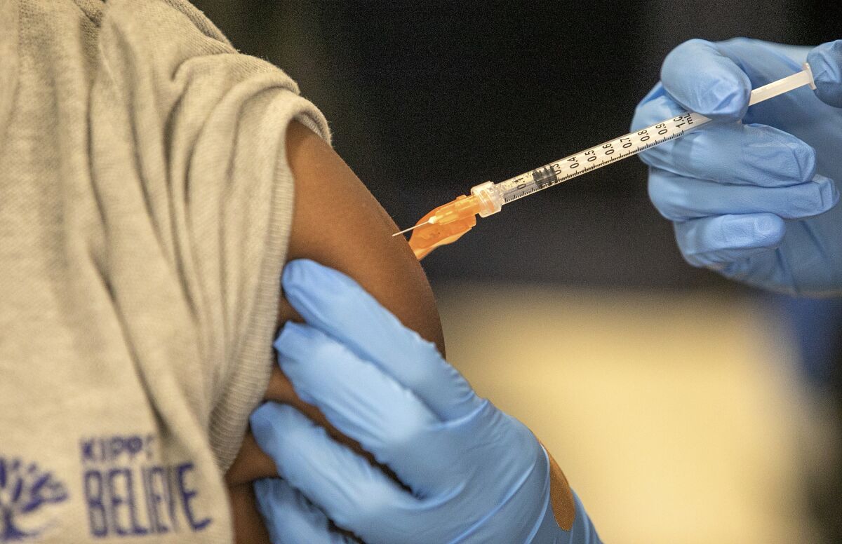 A student gets a COVID-19 vaccine at a school in New Orleans. 
