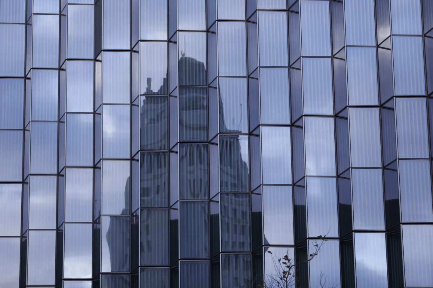 Los Angeles City Hall is surrounded by cloudy skies in a reflection in the windows of the new U.S. Courthouse under construction on Jan. 4.