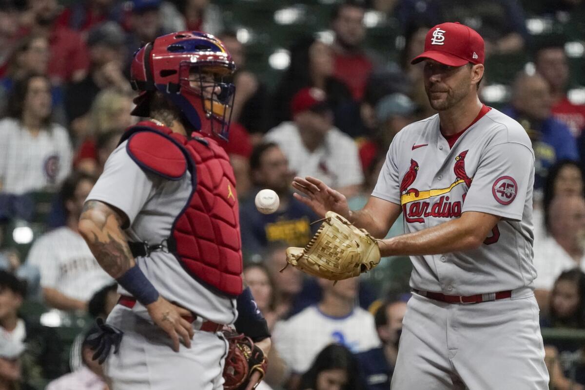 St. Louis Cardinals pitcher Adam Wainwright gets a new ball as catcher Yadier Molina watches.