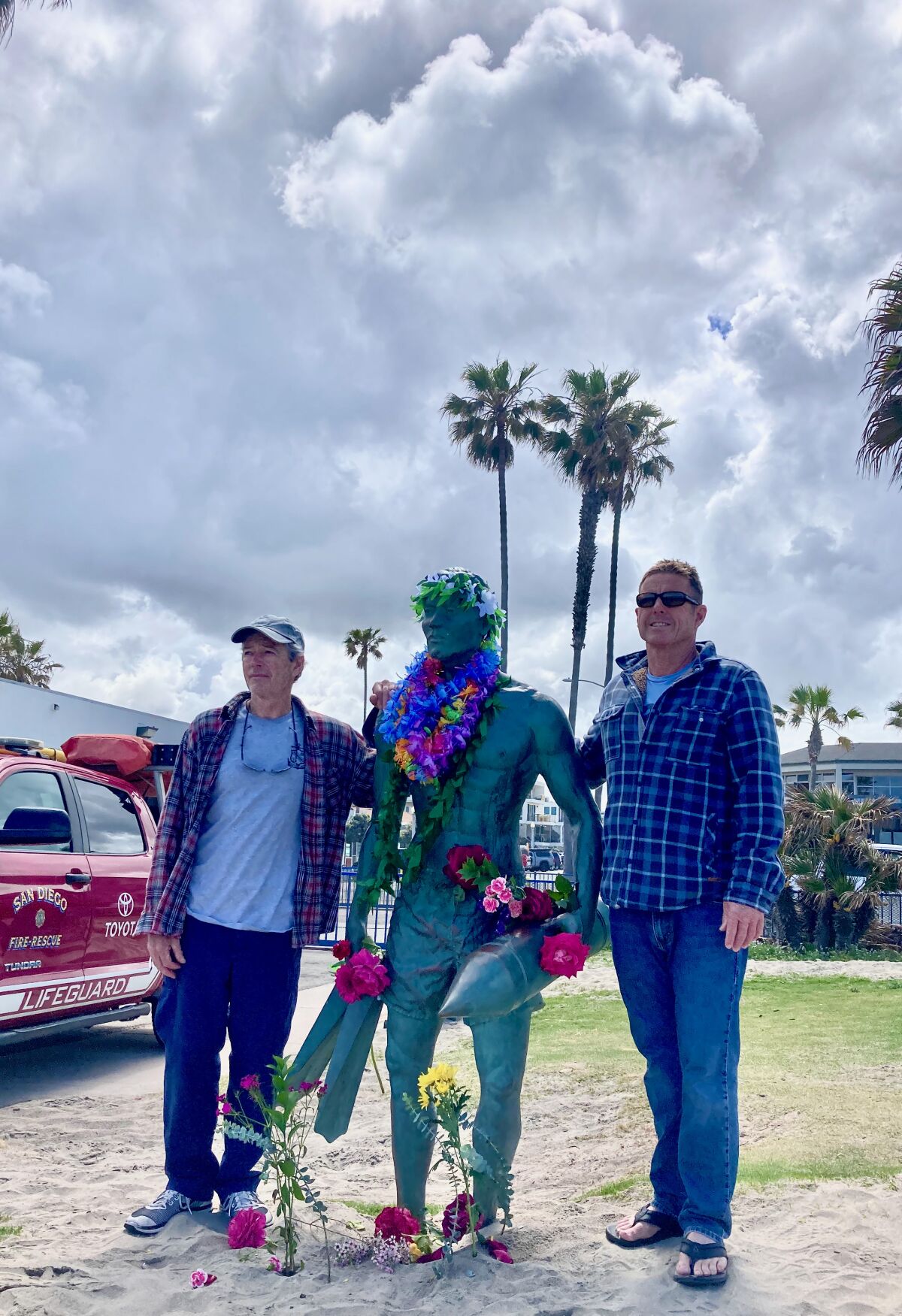 Retired lifeguard Sgt. Darrell Esparza and active lifeguard Lt. Rick Strobel visit Ocean Beach's lifeguard monument.