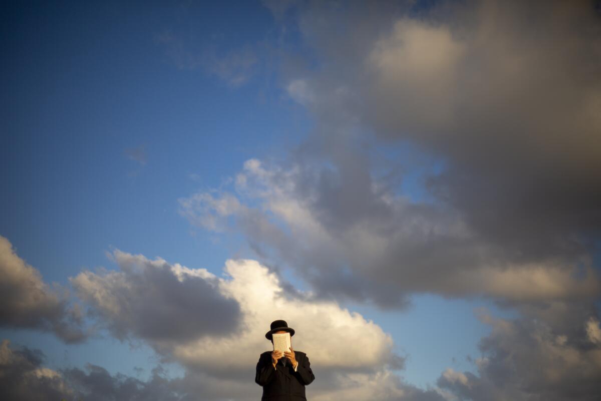 An Ultra-Orthodox Jewish man of the Kiryat Sanz Hasidic sect prays on a hill overlooking the Mediterranean Sea as they participate in a Tashlich ceremony, in Netanya, Israel, Tuesday, Sept. 14, 2021. Tashlich, which means "to cast away" in Hebrew, is the practice in which Jews go to a large flowing body of water and symbolically "throw away" their sins by throwing a piece of bread, or similar food, into the water before the Jewish holiday of Yom Kippur. (AP Photo/Ariel Schalit)