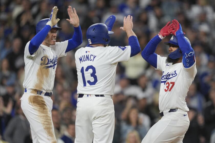 Los Angeles Dodgers' Teoscar Hernandez (37) celebrates his three-run home run with Max Muncy (13) and Freddie Freeman during the sixth inning of a baseball game against the San Francisco Giants, Monday, April 1, 2024, in Los Angeles. Max Muncy and Freddie Freeman also scored. (AP Photo/Ryan Sun)