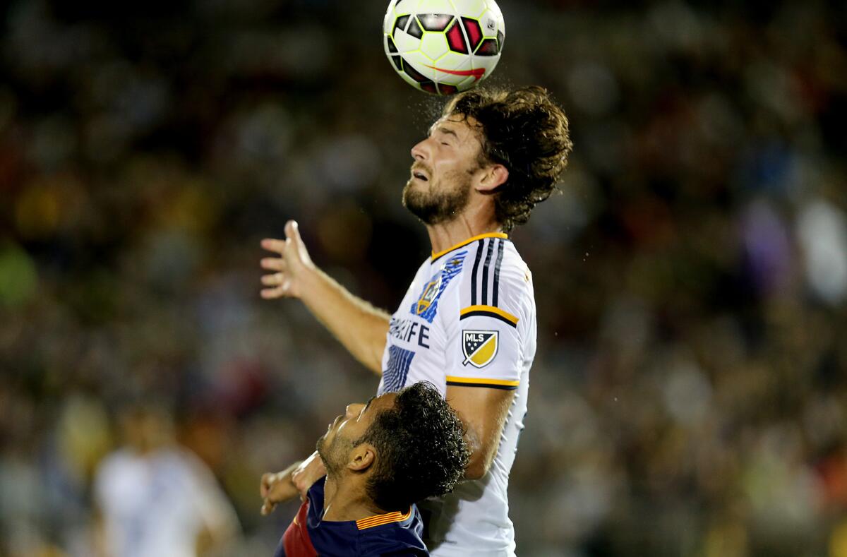 Galaxy defenseman Tommy Meyer goes up for a header against FC Barcelona defenseman Douglas in the second half of an International Champions Cup match at the Rose Bowl on Tuesday.