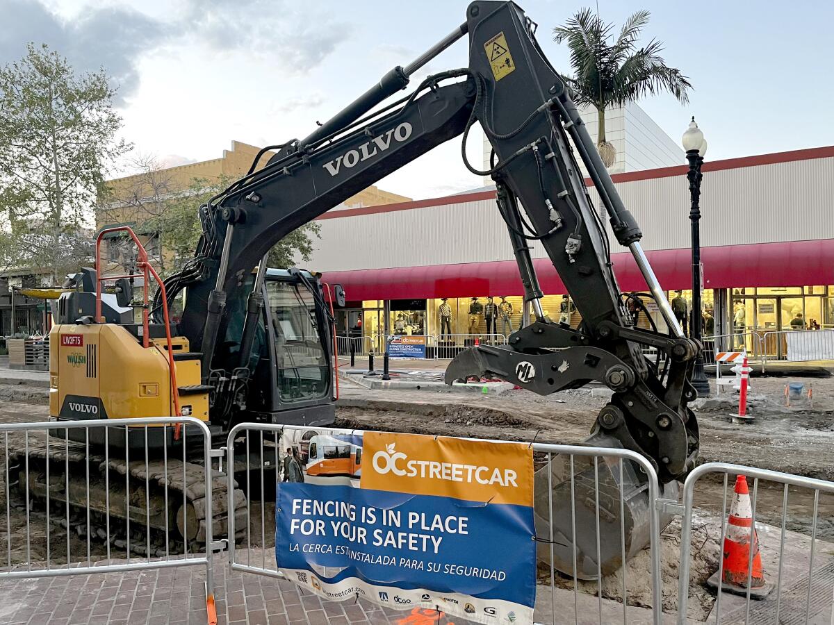 An excavator sits in the middle of 4th Street in downtown Santa Ana, which has become a streetcar trolly construction site.