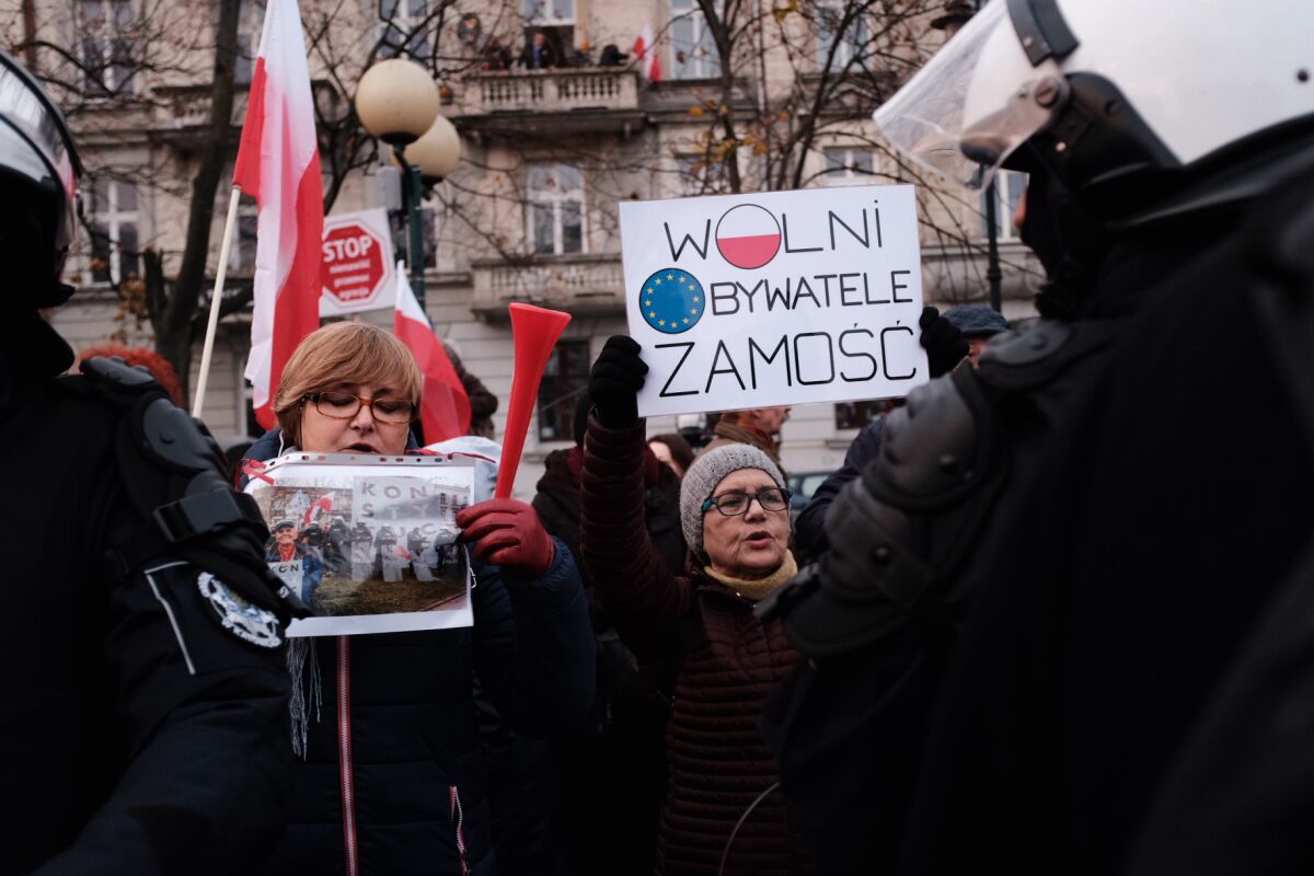 Counter-demonstrators hold signs saying "Constitution" and "Free Citizens Zamosc." In recent years, Polish authorities were accused of breaching the rule of law, leading to public discontent and mass protests in cities across the country.
