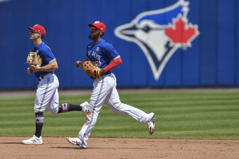 The Blue Jays' Randal Grichuk, left, and Teoscar Hernandez jog to the dugout during a game July 4, 2021, in Buffalo, N.Y.