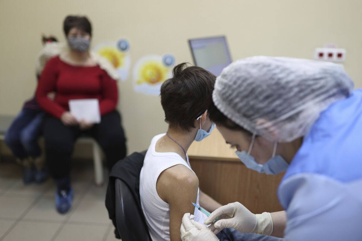 A teenager receives a dose of Russia's Sputnik M (Gam-COVID-Vac-M) COVID-19 vaccine in Krasnodar, Russia, Friday, Feb. 4, 2022. The Russian president says his government is considering loosening some coronavirus restrictions, even as the country is facing a record-breaking surge of infections because of the highly contagious omicron variant. (AP Photo/Vitaliy Timkiv)