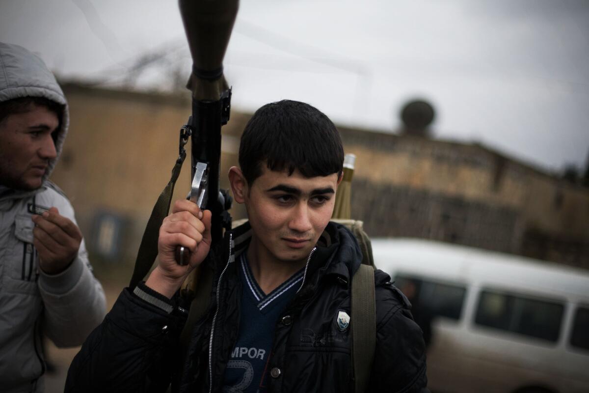 A file photo shows a Free Syrian Army fighter with his weapon as he prepares for an advance near Azaz, Syria. An Al-Qaeda-linked group has now taken control of the town.