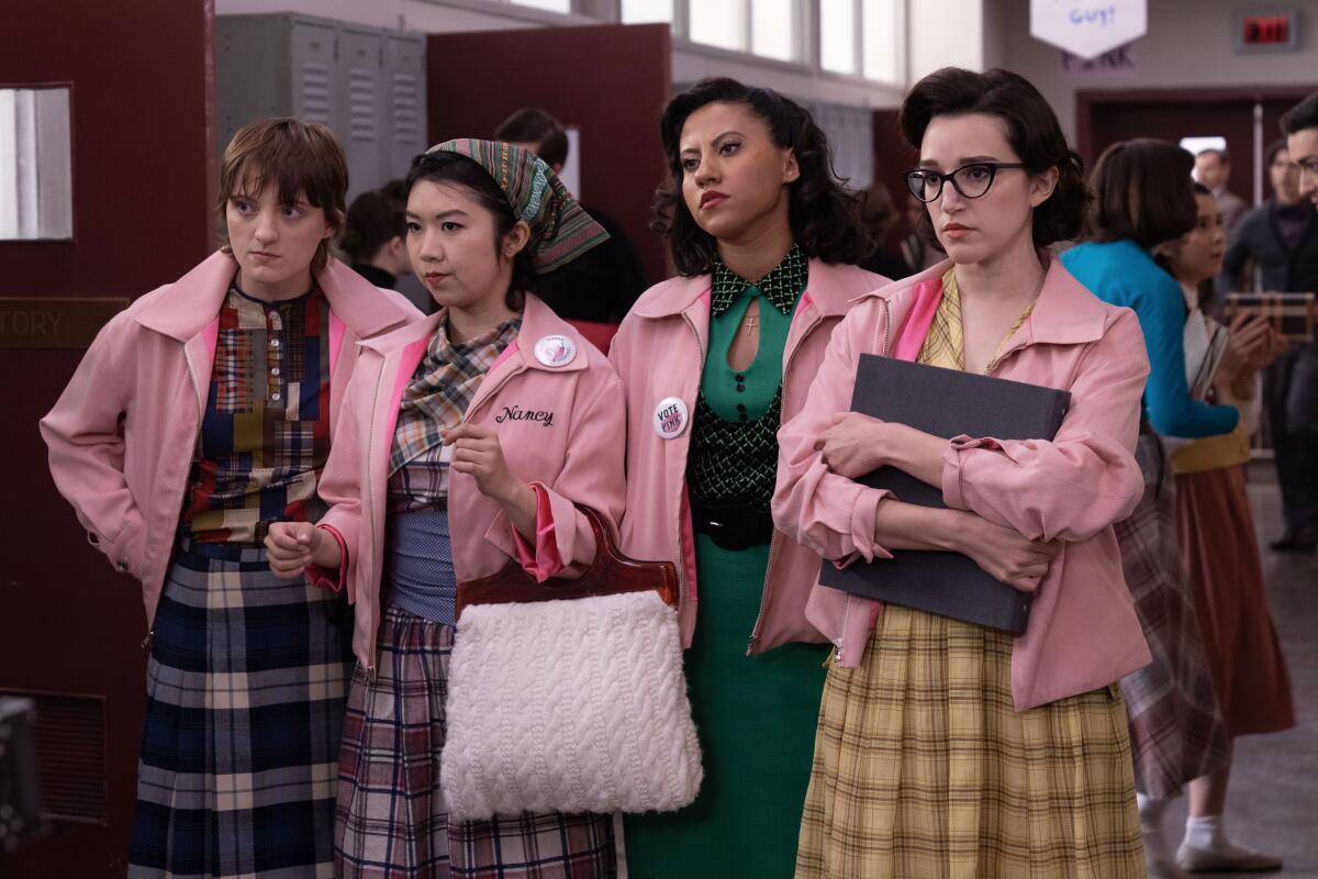 Four 'Pink Ladies' from Grease glower in a high-school hallway