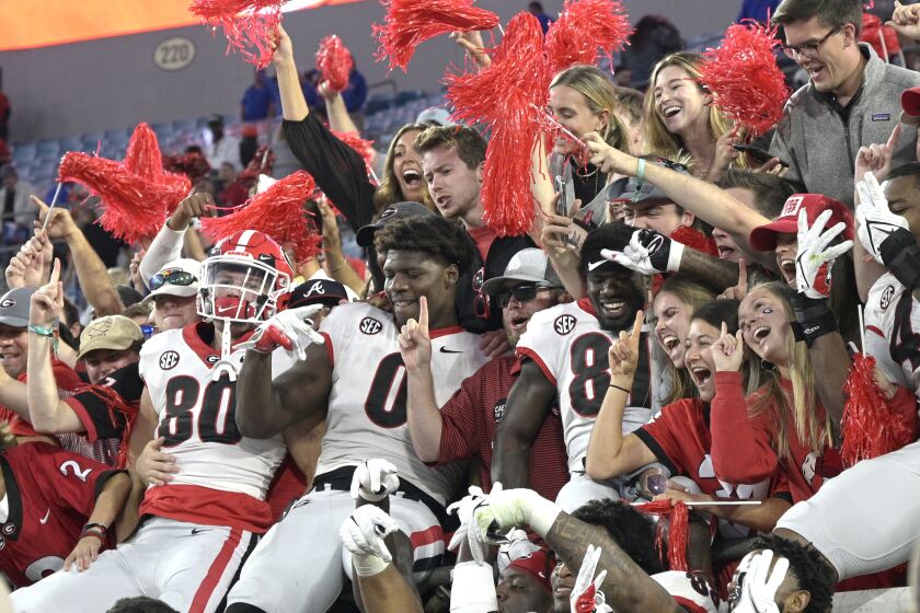 Georgia players celebrate with fans in the stands after getting the win over Florida in an NCAA college football game, Saturday, Oct. 30, 2021, in Jacksonville, Fla. (AP Photo/Phelan M. Ebenhack)