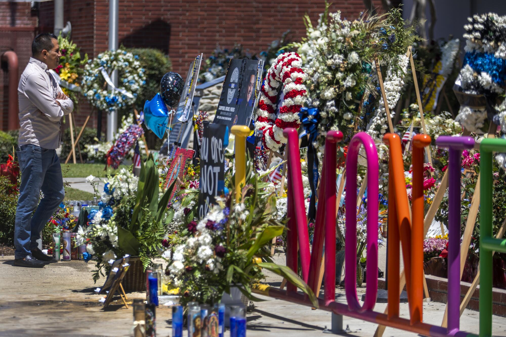 People continue to drop by El Monte Police Department headquarters and look at a memorial