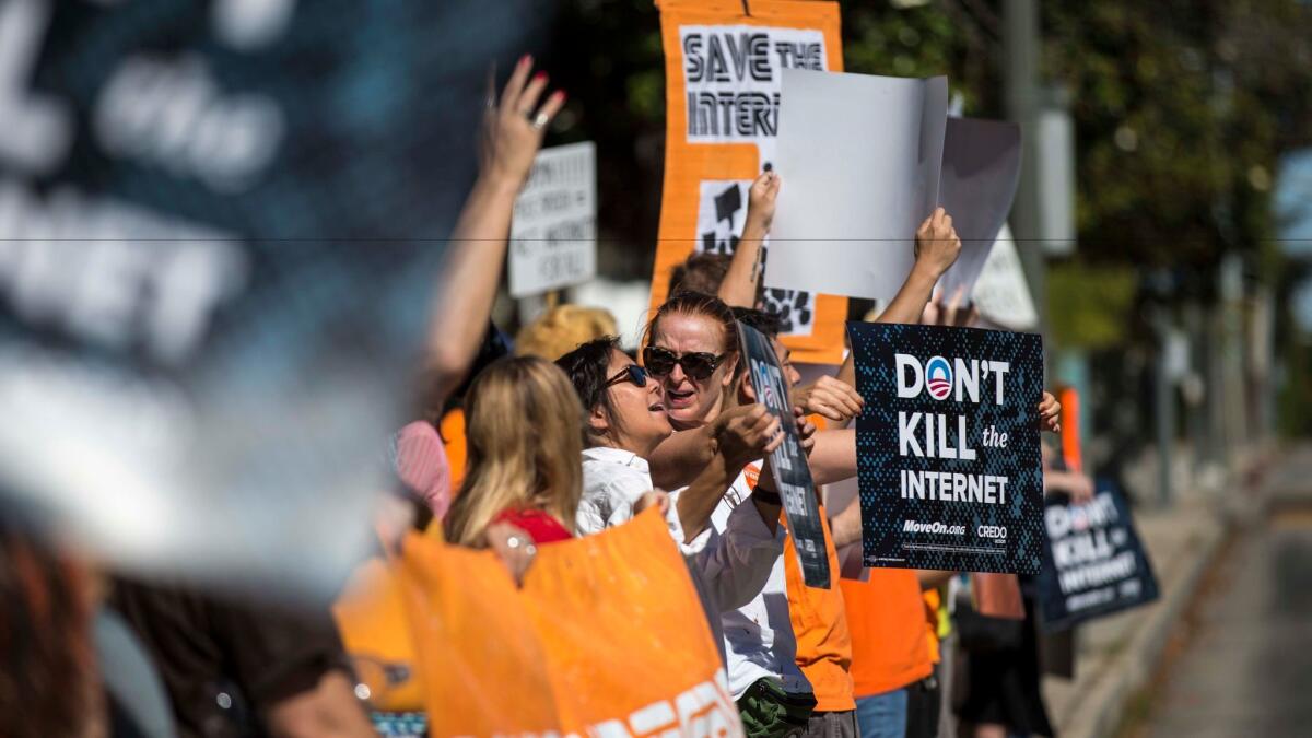 Protesters in 2014 hold signs urging President Obama to save net neutrality outside the Memorial Branch of the Los Angeles Public Library.