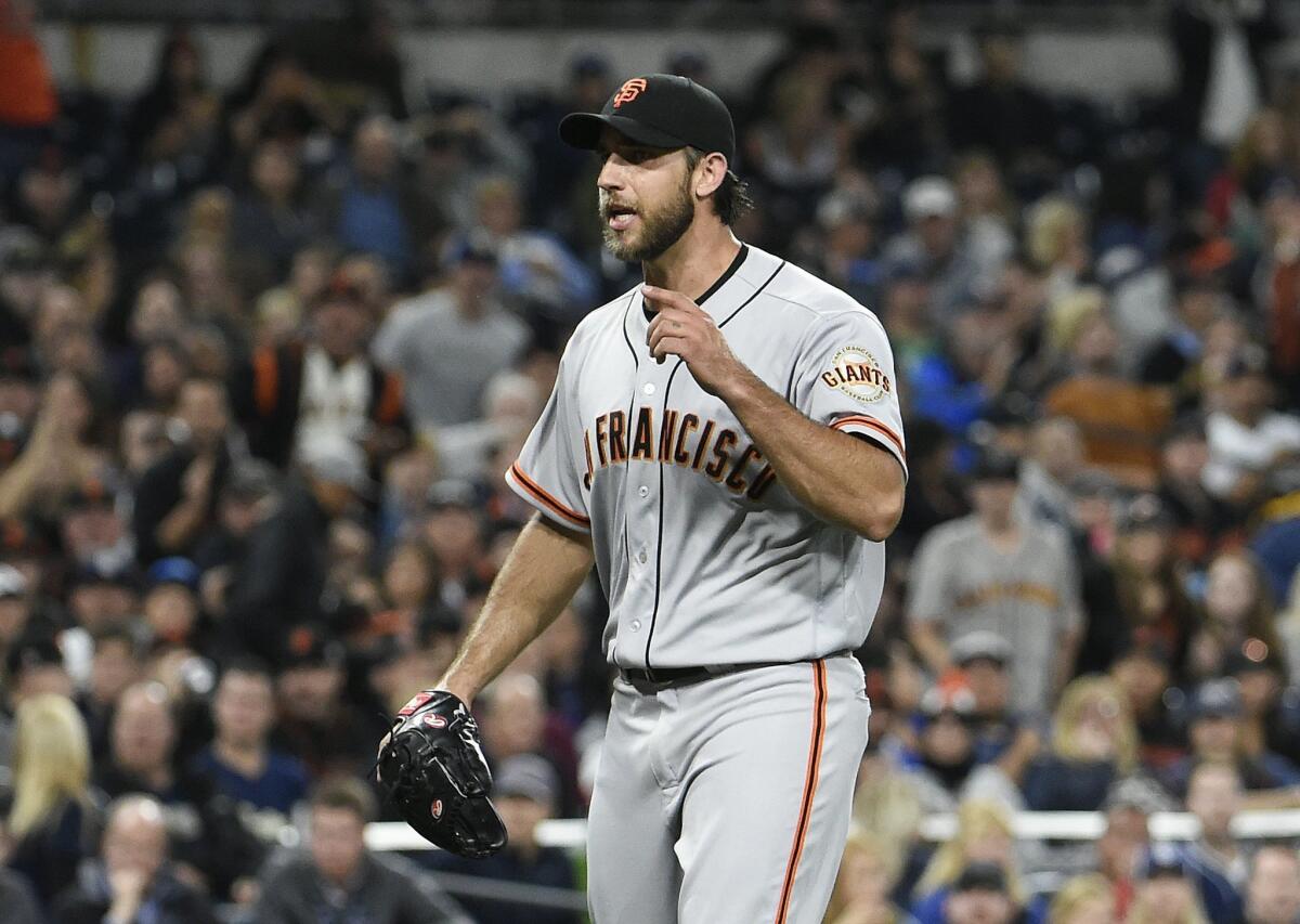 San Francisco Giants starting pitcher Madison Bumgarner touches his beard  as he walks back to the mound while working against the San Diego Padres  during the third inning of a baseball game