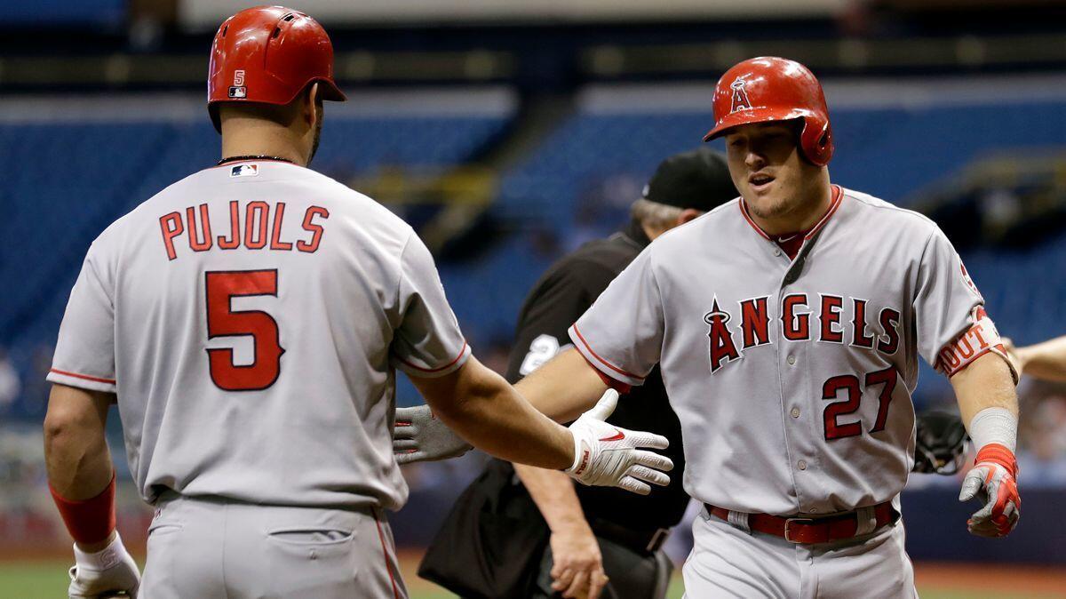 Angels center fielder Mike Trout celebrates with Albert Pujols after Trout hit a home run on Tuesday.
