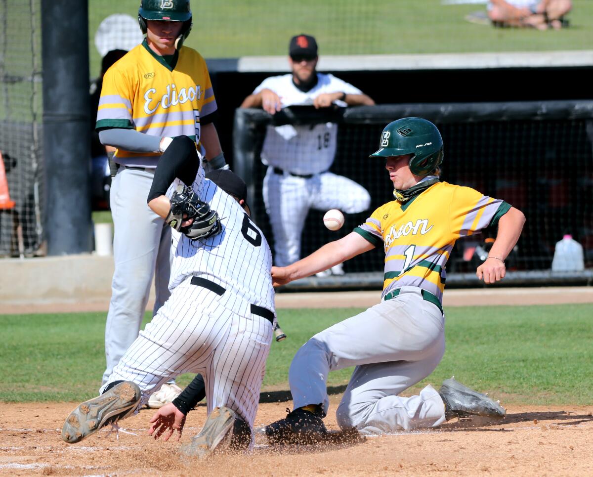 Edison third baseman Dylan Richardson slides in safely into home and scores vs. Huntington Beach on Wednesday.