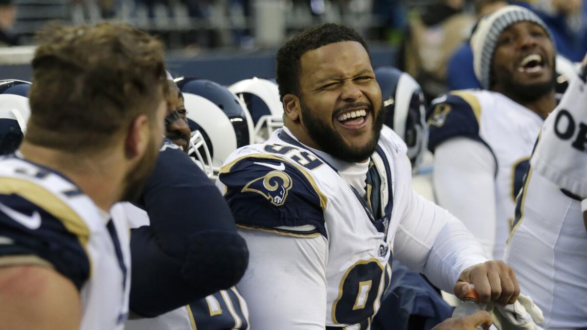 Rams defensive end Aaron Donald, center, smiles with teammates on the bench during a game against Seattle
