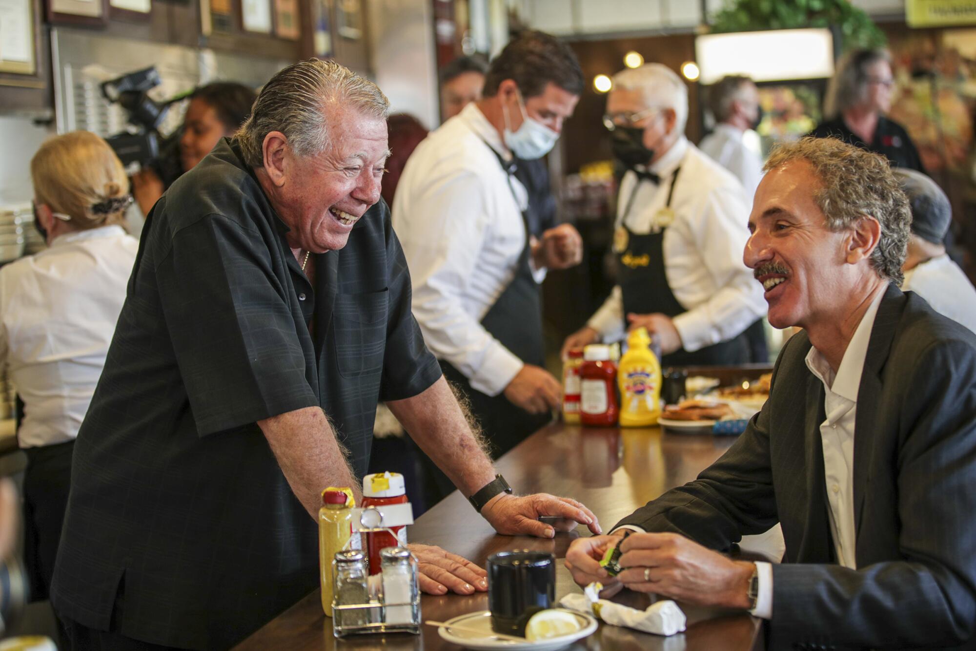 Two people talk and laugh at a restaurant 