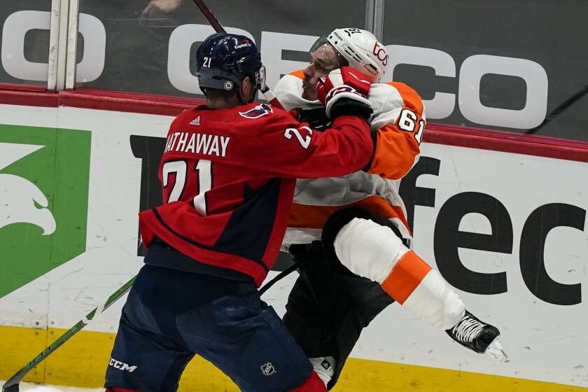 Washington Capitals right wing Garnet Hathaway (21) collides with Philadelphia Flyers defenseman Justin Braun (61) during the second period of an NHL hockey game, Friday, May 7, 2021, in Washington. (AP Photo/Alex Brandon)