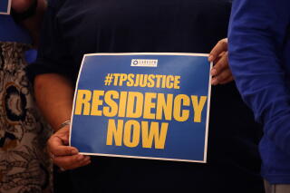 Signs at a news conference to provide an update on the status of TPS designation for Salvadoran immigrants.