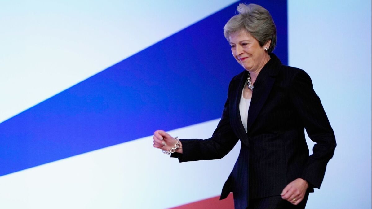 British Prime Minister Theresa May dances as she walks out onto the stage to deliver her leader's speech during the final day of the Conservative Party Conference in Birmingham, England on Oct. 3.