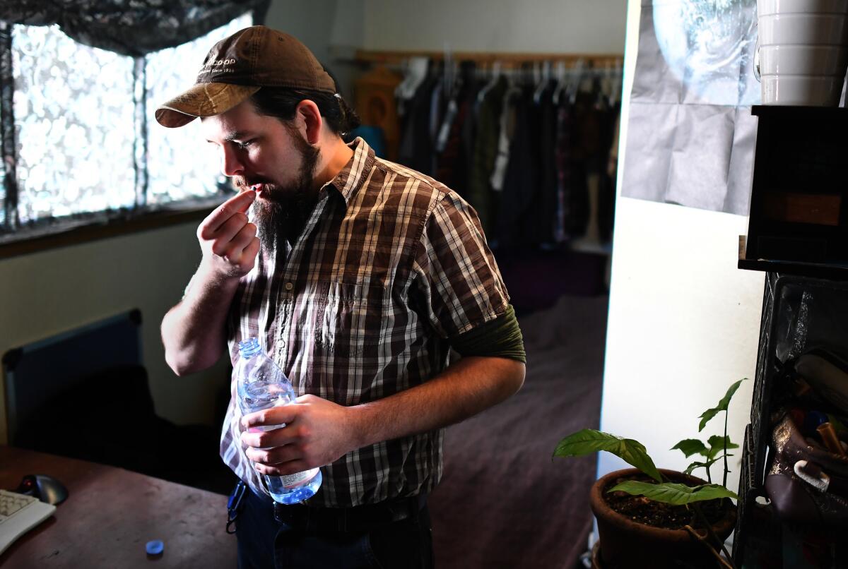 Rand Hunt takes pre-exposure prophylaxis, or PrEP, medication in his bedroom in Oakland on a recent morning. Hunt, 34, who was born the year HIV was identified, has lived his entire life in the shadow of the AIDS epidemic.