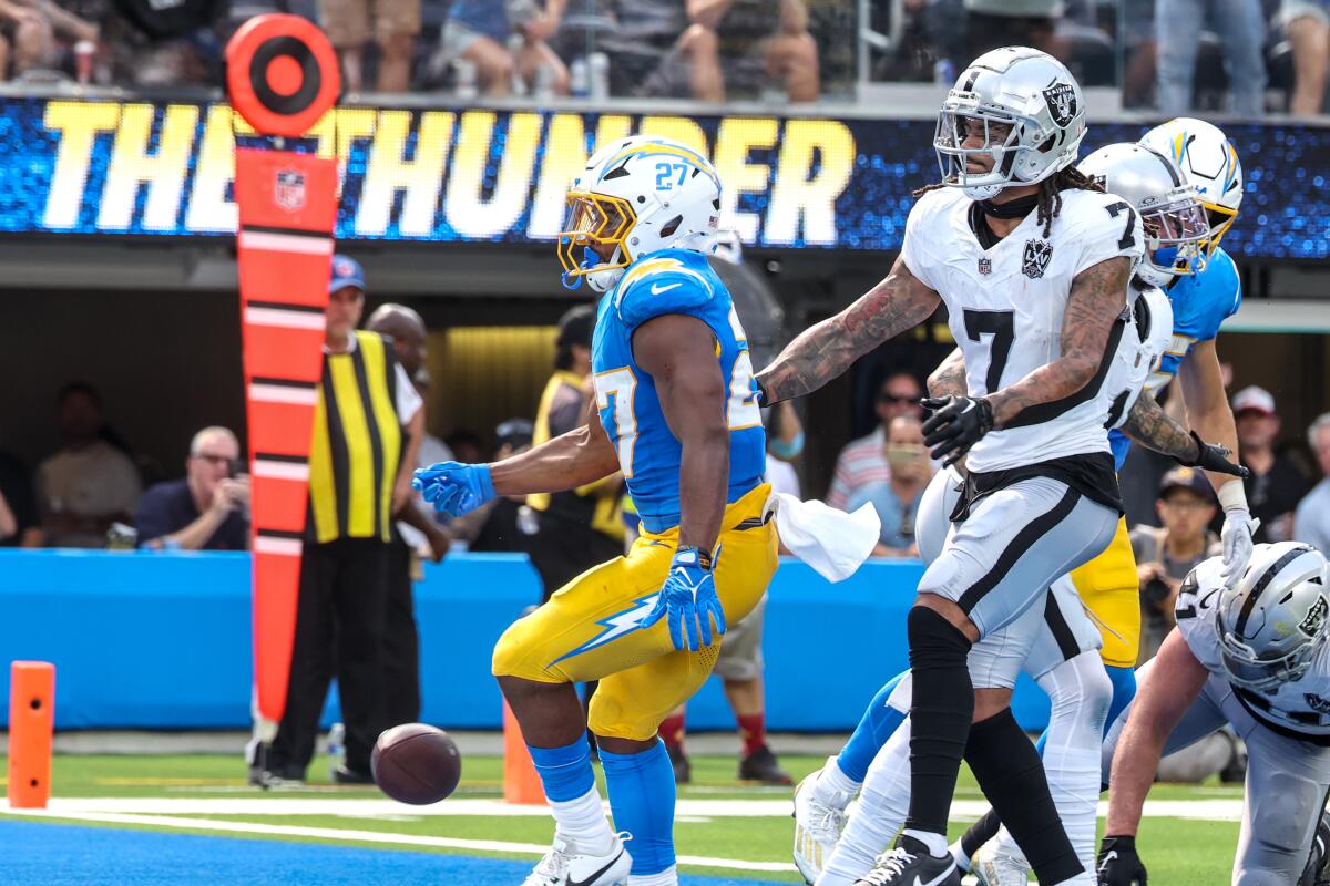 Chargers running back J.K. Dobbins (27) scores a fourth-quarter touchdown past Raiders safety Tre'von Moehrig (7).