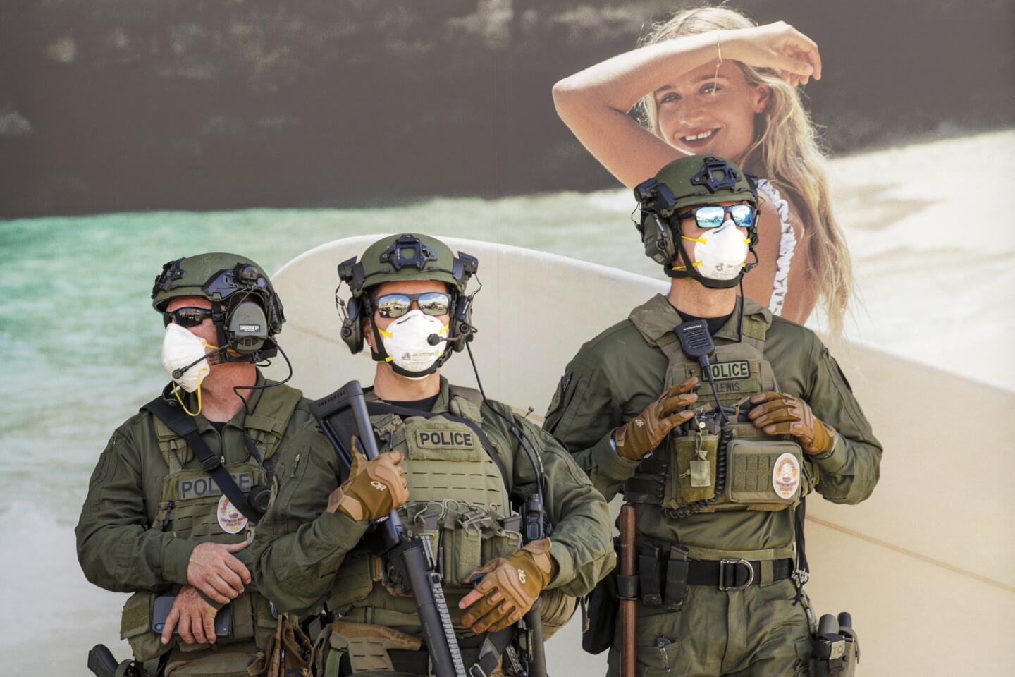 Police keep an eye on Trump supporters at a rally on Main Street against business closure due to COVID-19 pandemic. Huntington Beach, CA.