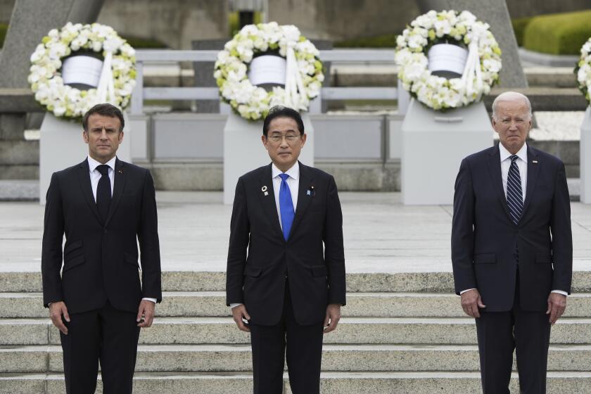 President Biden with French President Emmanuel Macron, left, and Japan's Prime Minister Fumio Kishida.