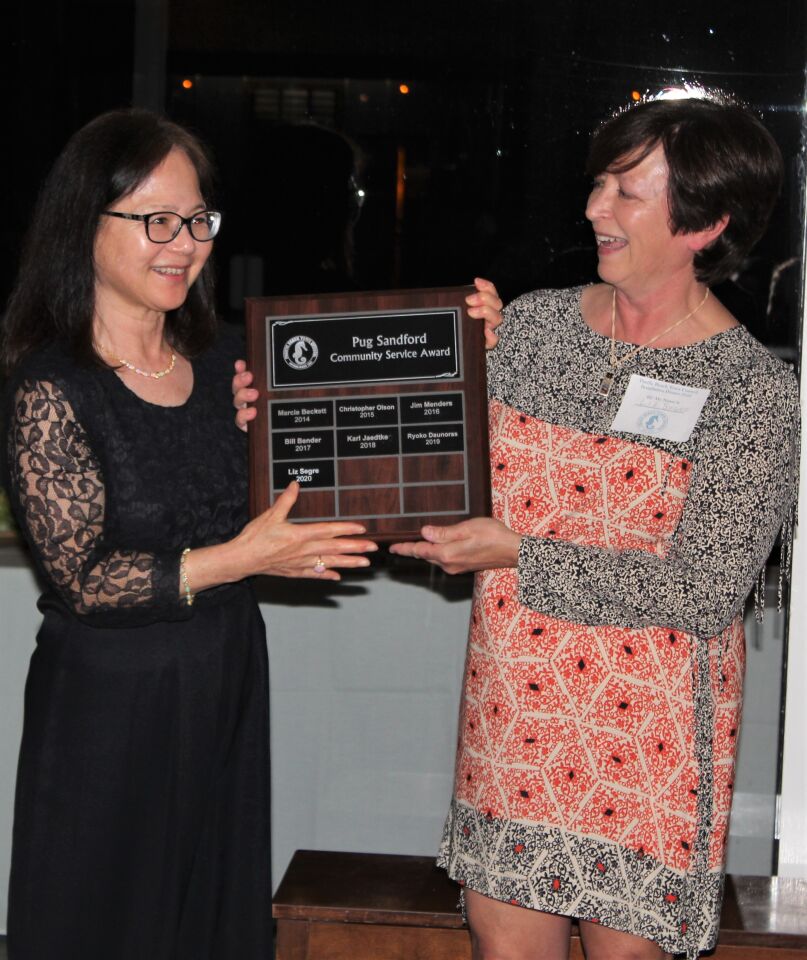Last year’s Pug Sandford Community Service Award honoree Ryoko Daunoras with this year’s winner, PBTC office manager Liz Segre