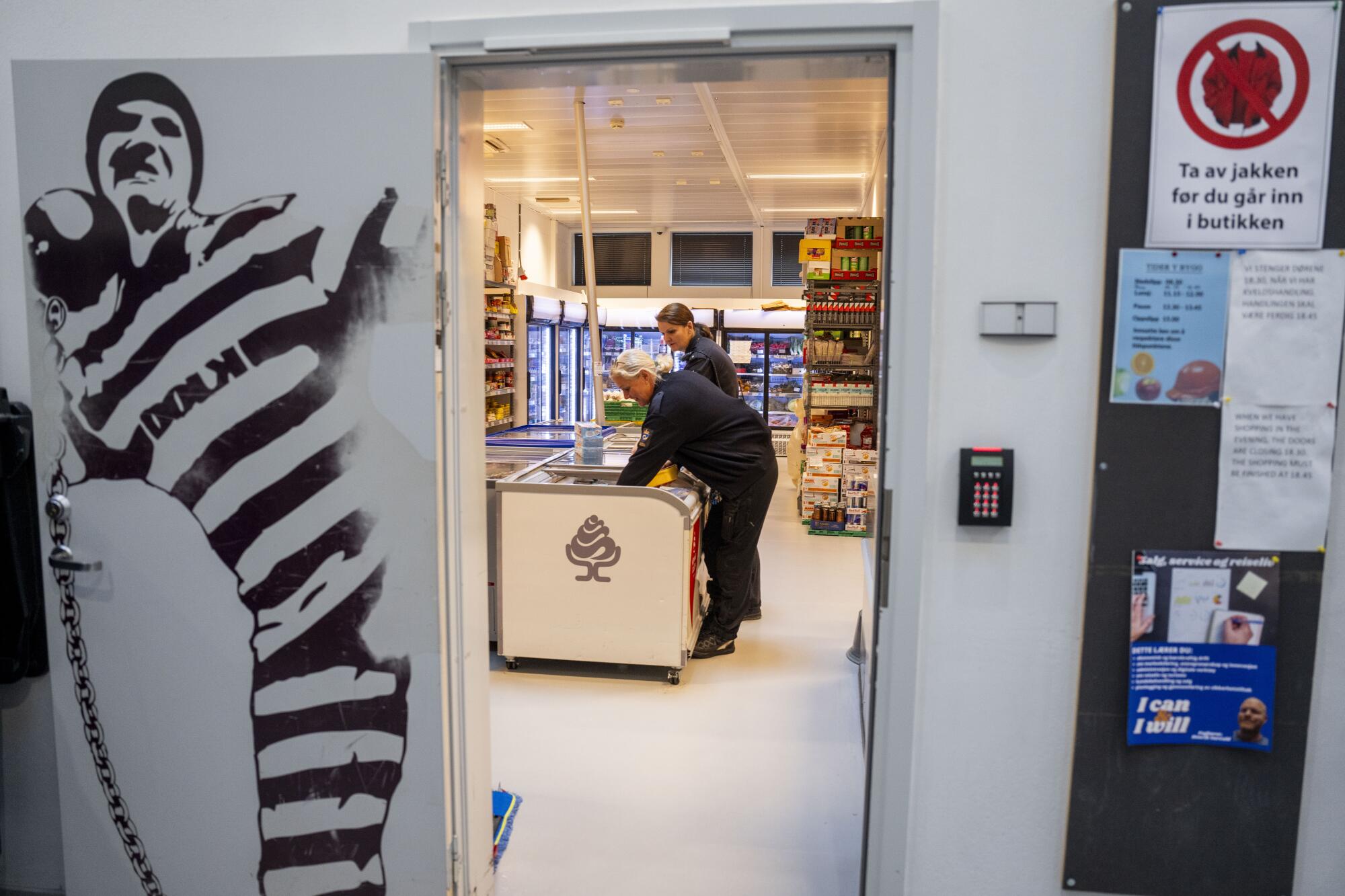 A correctional officer checks out the ice cream freezer in the grocery store inside the prison. 