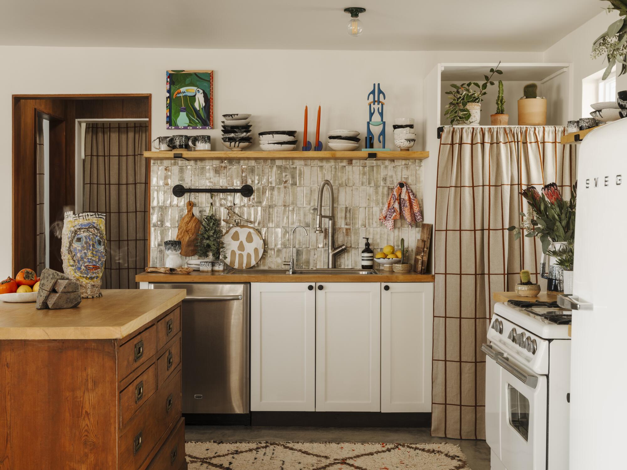 A kitchen with a walnut island and white ceramic backsplash.