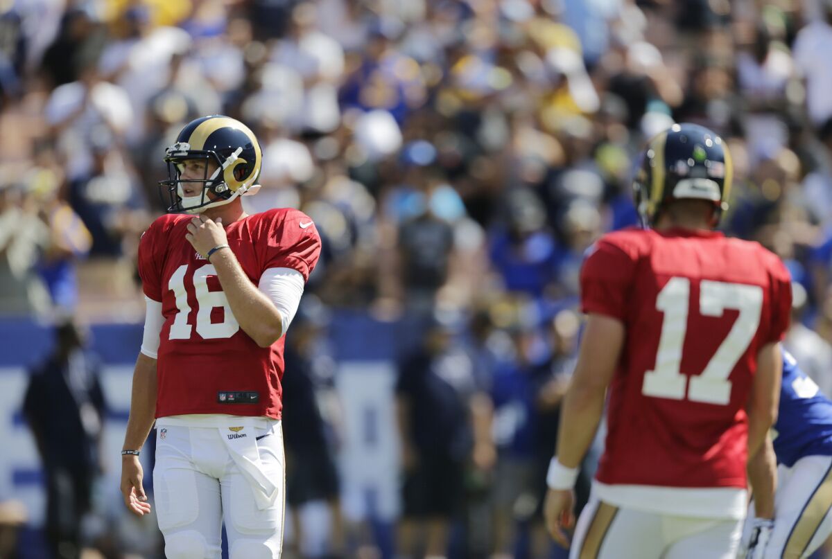 Rams rookie quarterback Jared Goff (16) makes an impression with starting quarterback Case Keenum (17) during a team scrimmage at the Coliseum on Saturday.