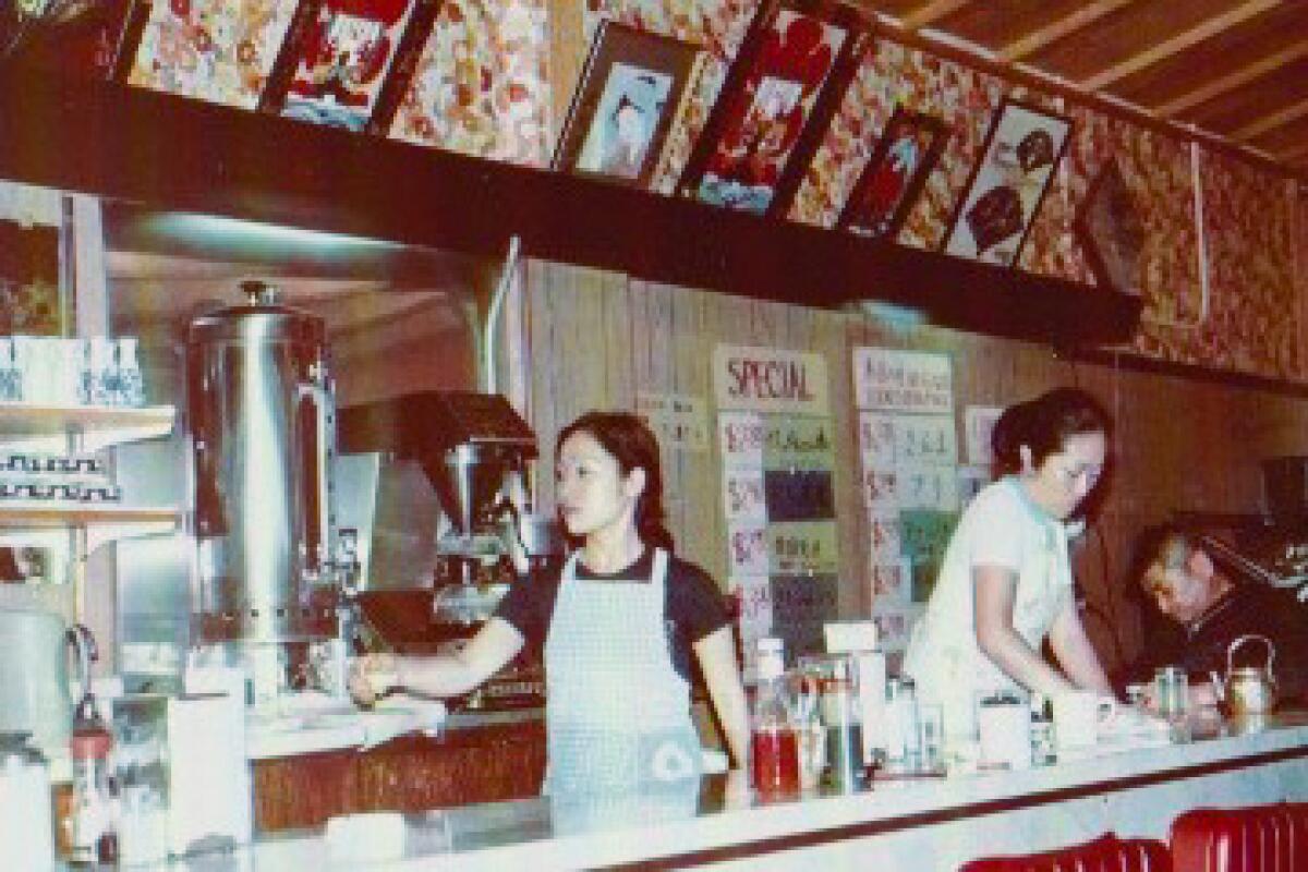 An old photo of people working behind a counter at Suehiro