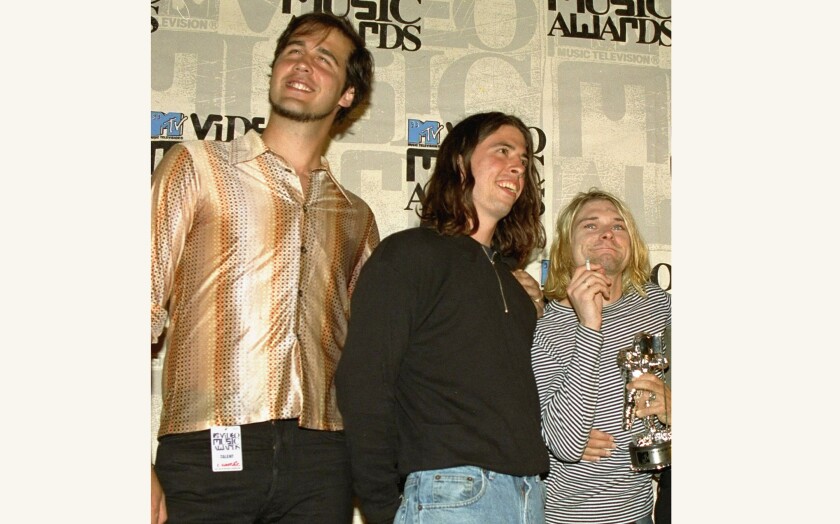 FILE - Nirvana band members, from left, Krist Novoselic, Dave Grohl and Kurt Cobain pose after receiving an award for best alternative video at the 10th annual MTV Video Music Awards in Universal City, Calif., on Sept. 2, 1993. A federal judge has dismissed the lawsuit of a 30-year-old man who alleged that the image of him nude as a baby on the 1991 cover of Nirvana’s “Nevermind" is child pornography. Judge Fernando Olguin granted the motion by Nirvana's attorneys to dismiss the case Monday, Jan. 3, 2022 but said plaintiff Spencer Elden can refile an amended version of the suit. (AP Photo/Mark J. Terrill, File)