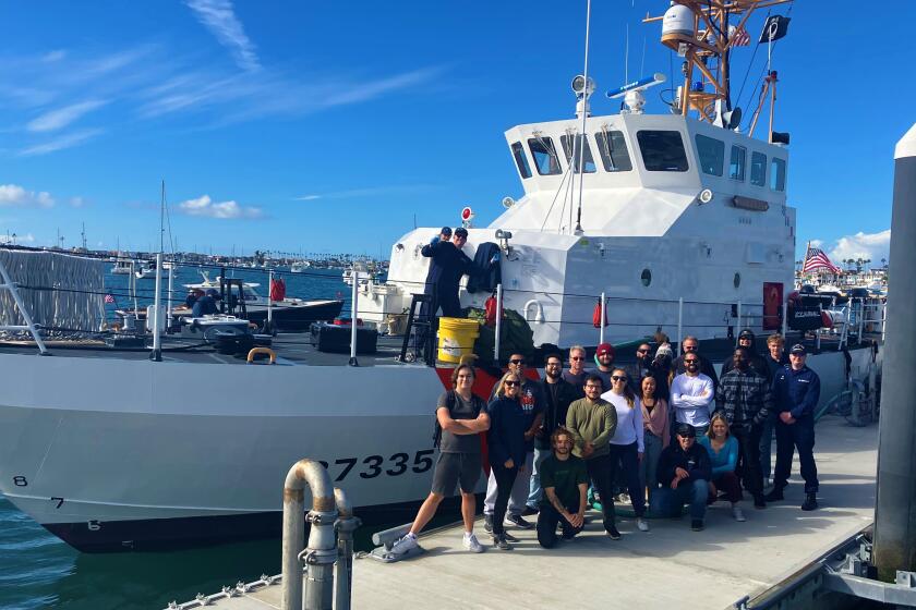 Students in Orange Coast College's Professional Maritime Program pose with a patrol boat near the school's waterfront campus.