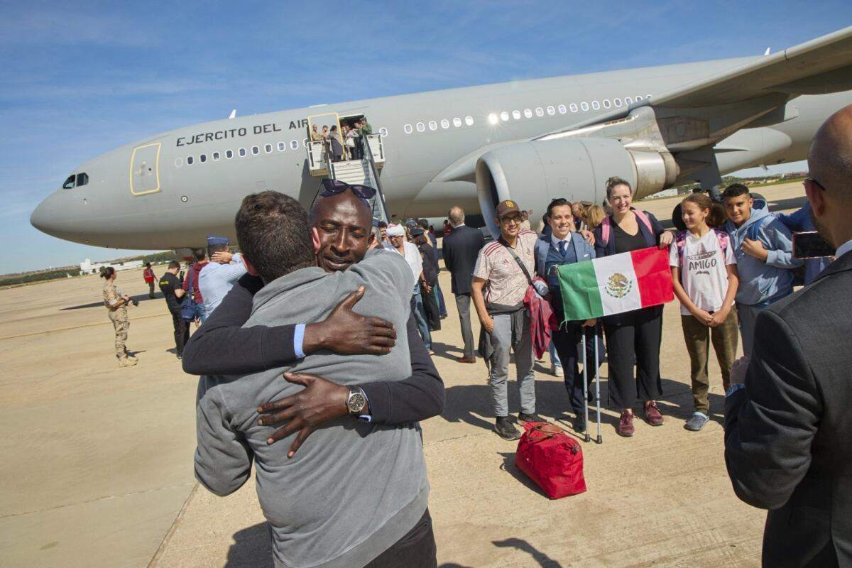 Pasajeros evacuados de Sudán se bajan de un avión de la fuerza aérea española 