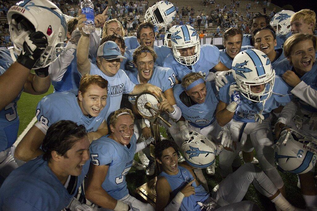 Corona del Mar High football players celebrate after defeating Newport Harbor, 24-3, in the Battle of the Bay at Orange Coast College Thursday night.