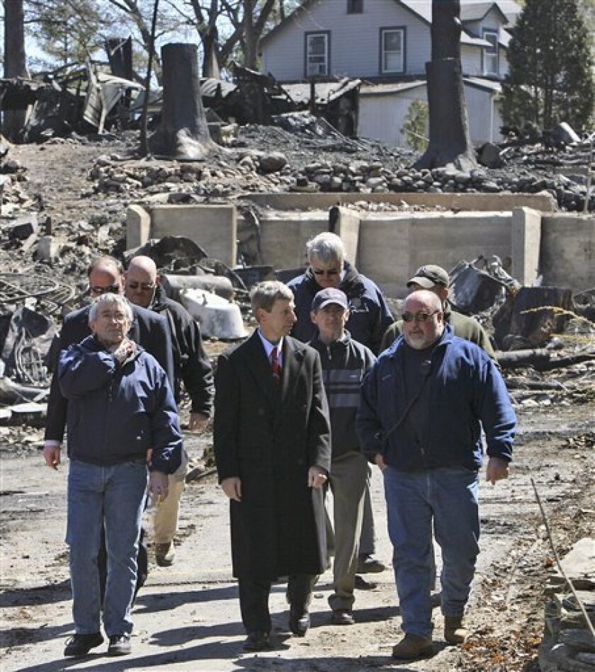 Gov. John Lynch, front center, talks with Alton Fire Chief Scott Williams, right, as they tour the Christian Center compound in Alton Bay, N.H. Monday April 13, 2009, the day after a fire swept through compound Sunday, destroying at least 40 cottages. (AP Photo/Jim Cole)